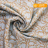 Roll of patterned fabric with gold design on a white background, labeled &